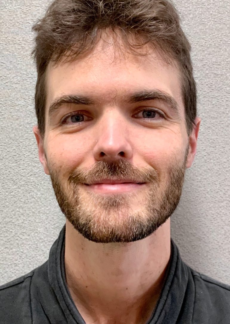 portrait of author: young white man with facial hair against white background
