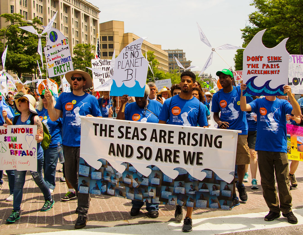 resist with us - activists carrying banners to protest climate change